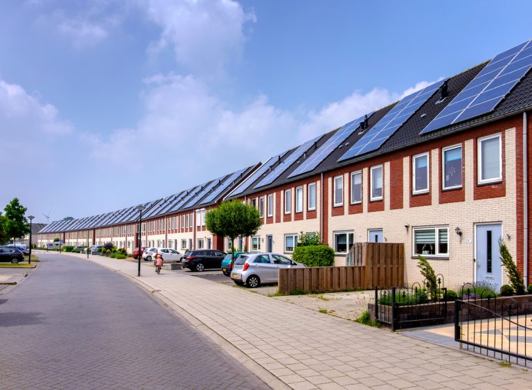 huizen in rijtje met zonnepanelen op dak 